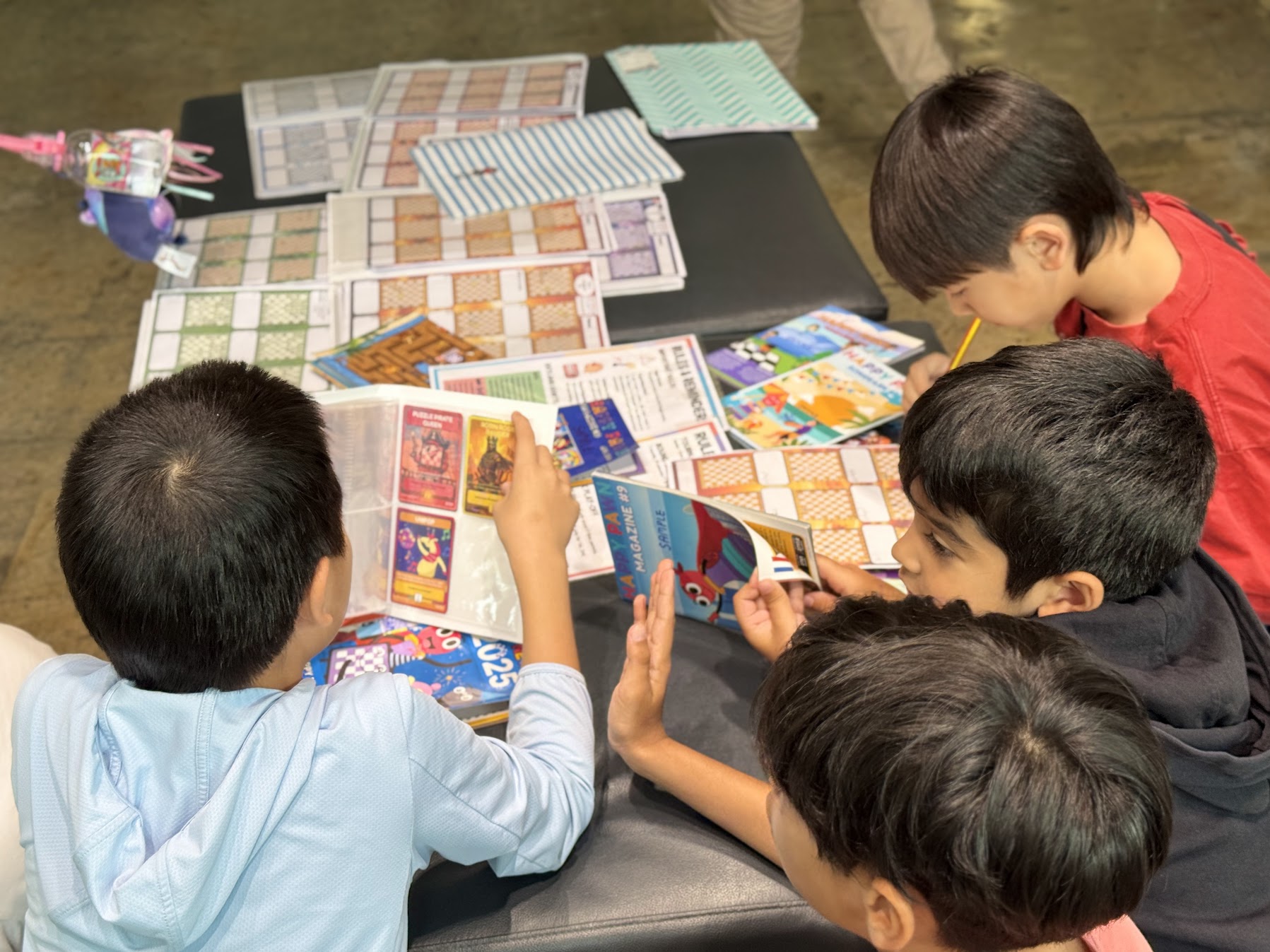Kids reading the Happy Pawn magazine and collectible cards