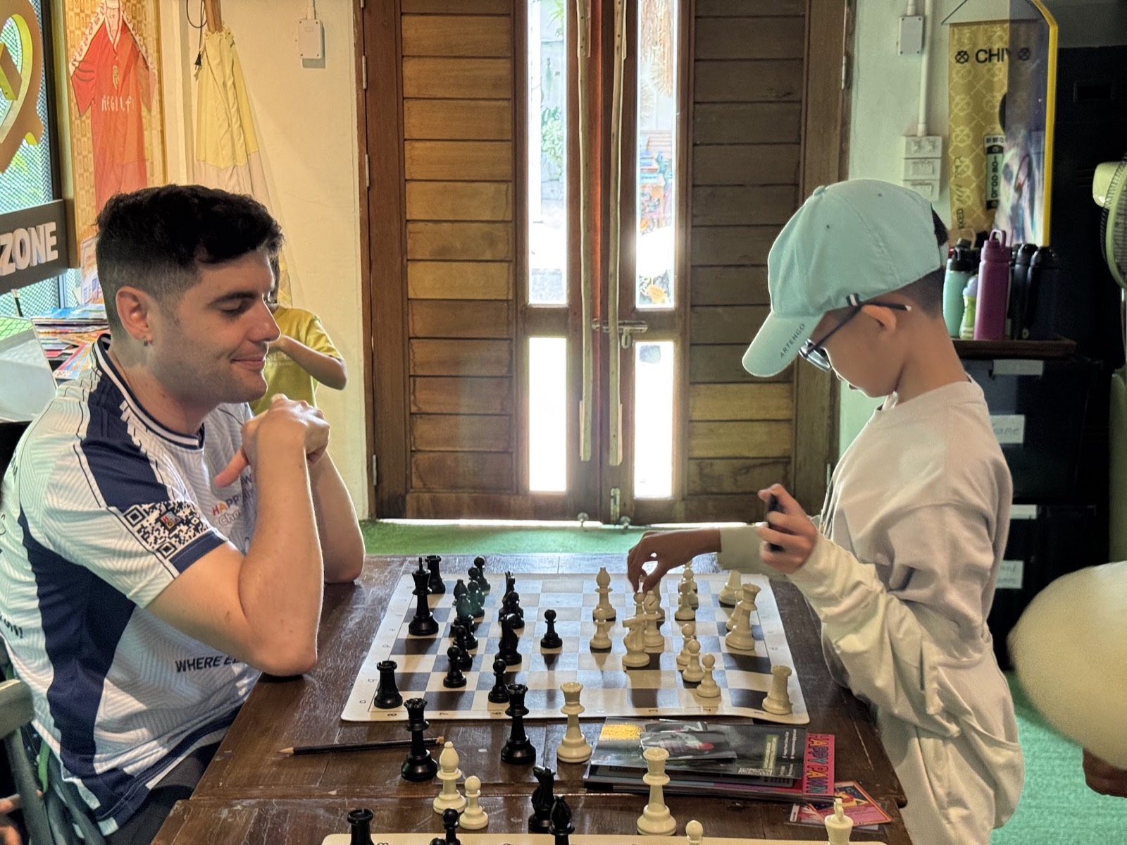 Coach and student playing chess one-on-one at a table